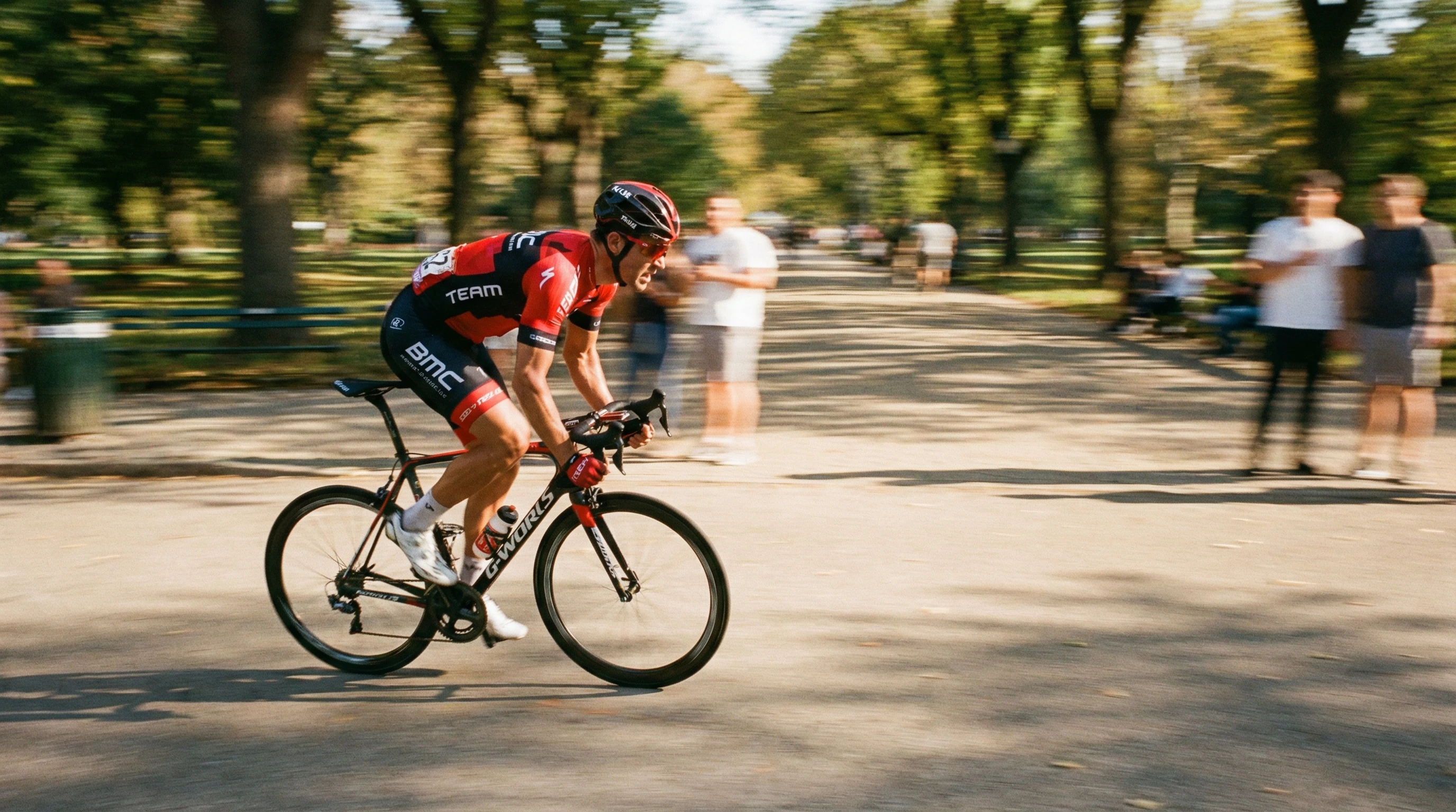 A panning action shot of a speeding cyclist against a blurred park background